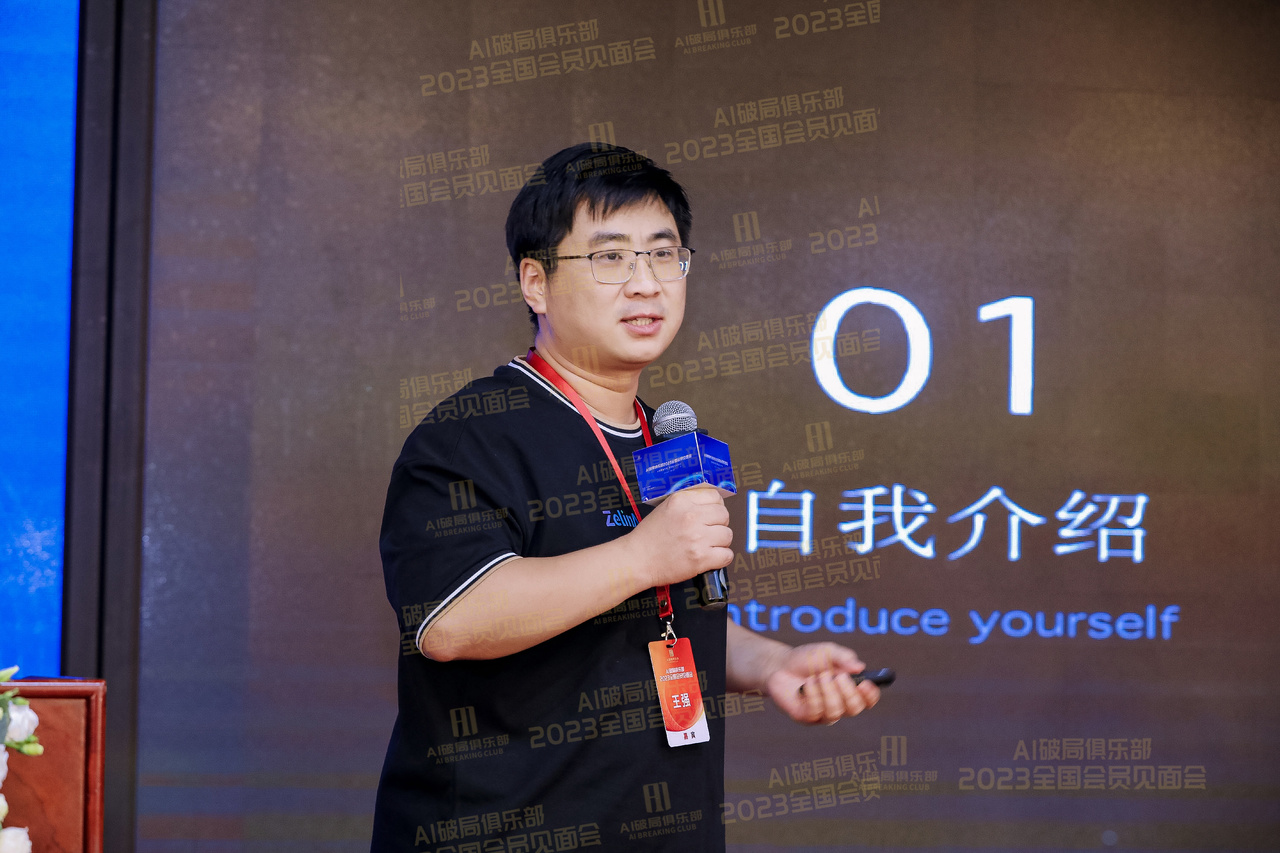图片展示的是AI破局俱乐部2023全国会员见面会现场。画面中一位男士手持话筒，身着黑色短袖，佩戴红色证件，背景为深色带有“2023全国会员见面会”字样的幕布，幕布上还有“自我介绍”及“Introduce yourself”字样。该图片与文档中强哥分享ZelinAI在企业及行业中的应用内容相关，可能是强哥在会议中进行自我介绍或分享的场景。