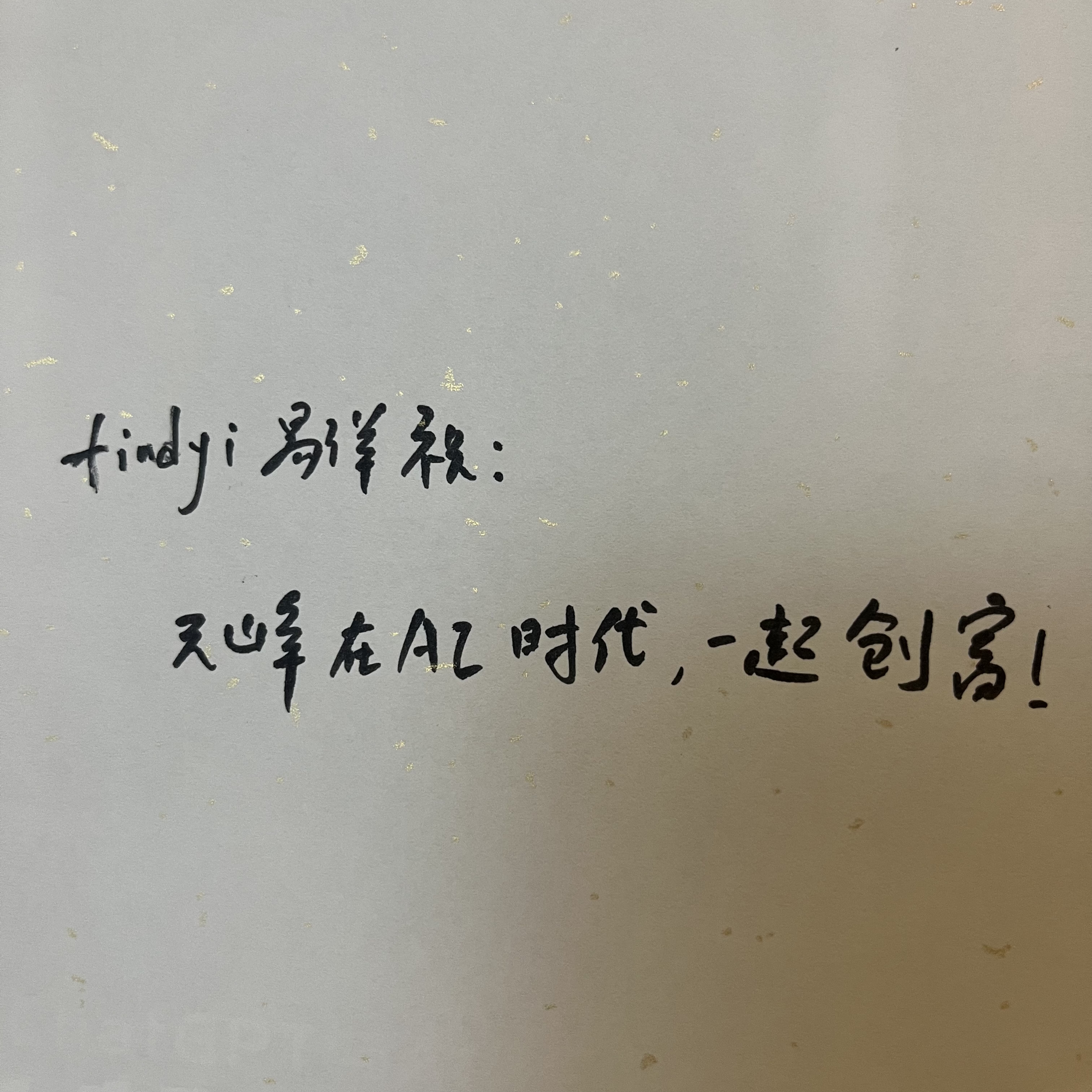 图片是一张手写纸，上面写着“findyi易洋祝：元峰在AI时代，一起创富！”字样。这张图片位于文档中“大佬们的晚餐”部分，可能是作者在与多位业界大佬共进晚餐时，被他们见识和洞察所吸引，记录下的一句祝福语。纸张上有明显的折痕，背景为浅色。