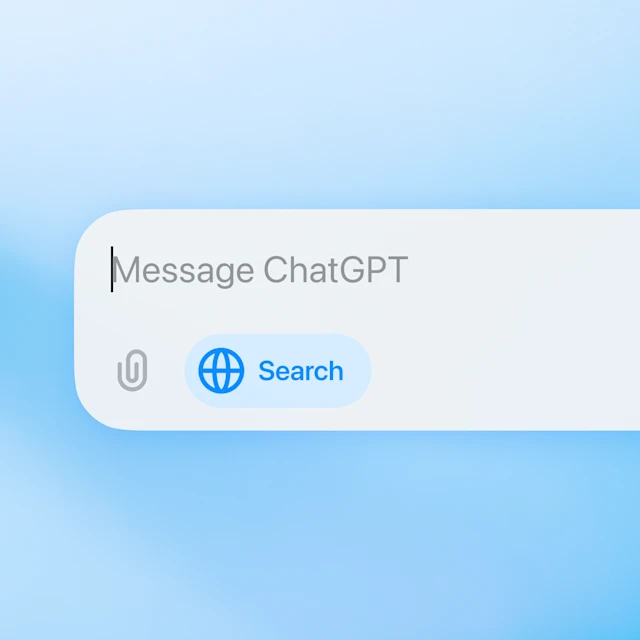 图片展示了ChatGPT界面中用于搜索的部分。可见输入框内显示“Message ChatGPT”,输入框下方左侧有一个回形针图标,右侧是蓝色的“Search”搜索按钮,按钮上还有一个地球图案。这与文档中提到的第8天OpenAI扩展ChatGPT搜索功能,向所有免费账户用户开放,且在所有支持平台上均可使用的内容相关,直观呈现了用户可进行搜索操作的入口。