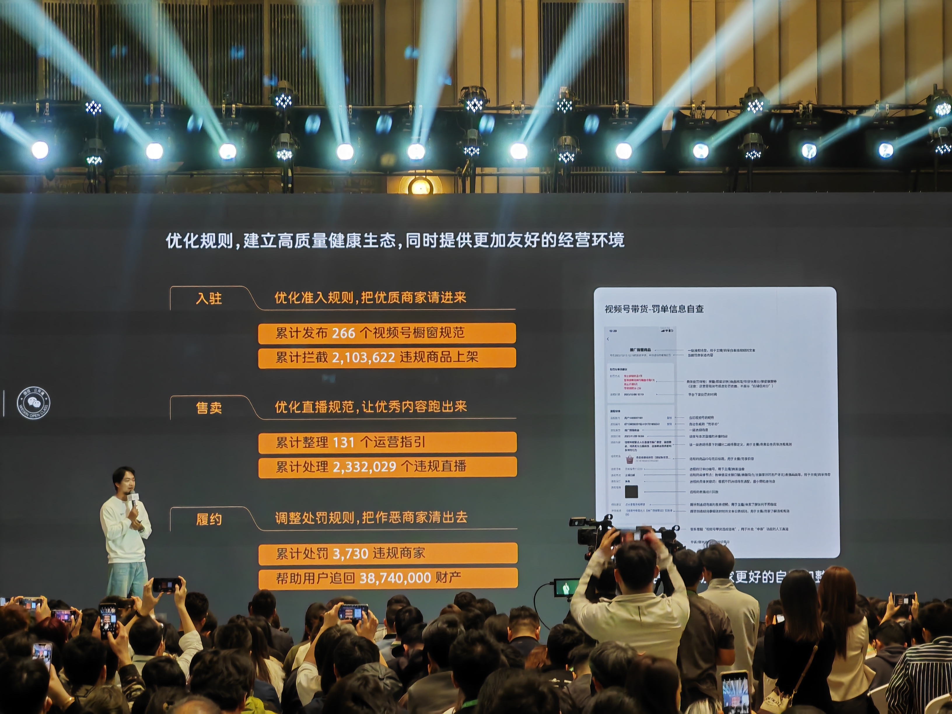 图片展示了2024「微信公开课」中关于视频号直播带货的分享场景,台上演讲者正在介绍相关内容。背景大屏上显示了优化视频号直播带货规则、建立高质量健康生态的举措,包括优化准入规则,累计发布266个橱窗规范、拦截超210万违规商品上架;优化直播规范,累计整理131个运营指引、处理超233万个违规直播;调整处罚规则,累计处罚3730个违规商家、帮用户追回超3874万元财产等。右侧还有视频号带货罚单信息自查示例。
